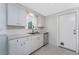 Bright kitchen features white cabinets, lots of counter space and stainless steel dishwasher at 1691 Lakeview Pl, Englewood, FL 34223