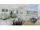 Bright living area with a comfortable sofa, armchairs, and a view of the backyard pond at 1691 Lakeview Pl, Englewood, FL 34223