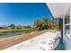 An outdoor patio features relaxing chairs with a tranquil canal view surrounded by lush greenery and palm trees at 1691 Lakeview Pl, Englewood, FL 34223