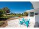 Relaxing patio featuring a table with blue metal chairs and a serene canal view with beautiful palm trees at 1691 Lakeview Pl, Englewood, FL 34223