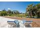 The patio boasts comfortable loungers perfect for enjoying the scenic water view with beautiful palm trees at 1691 Lakeview Pl, Englewood, FL 34223