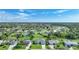 Expansive aerial view of a residential community with lush green lawns and beautiful homes under a partly cloudy sky at 171 Mark Twain Ln, Rotonda West, FL 33947