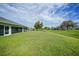 Expansive backyard with lush green grass and a covered lanai, creating a serene outdoor retreat at 171 Mark Twain Ln, Rotonda West, FL 33947
