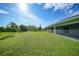 Expansive backyard featuring lush green grass and a screened lanai, perfect for outdoor living at 171 Mark Twain Ln, Rotonda West, FL 33947