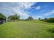 Large, verdant backyard providing plenty of space for activities and relaxation, with a view of neighboring homes at 171 Mark Twain Ln, Rotonda West, FL 33947