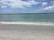 Calm ocean view with gentle waves lapping on a pristine sandy beach under a bright sky at 171 Mark Twain Ln, Rotonda West, FL 33947