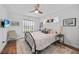 Bright bedroom boasts a comfortable bed, ceiling fan, and sunny window at 171 Mark Twain Ln, Rotonda West, FL 33947
