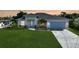 Charming home featuring a manicured lawn, a light blue front door and a two-car garage with an inviting curb appeal at 171 Mark Twain Ln, Rotonda West, FL 33947