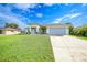Attractive single-Gathering home with a well-kept lawn, a two-car garage, and a bright blue sky backdrop at 171 Mark Twain Ln, Rotonda West, FL 33947