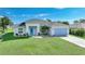 Inviting single-story home with a well-manicured lawn, featuring a modern blue front door and coordinated garage door at 171 Mark Twain Ln, Rotonda West, FL 33947