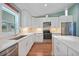 Modern kitchen features white cabinets, stainless steel appliances, and stone countertops at 171 Mark Twain Ln, Rotonda West, FL 33947