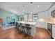 Open kitchen with island seating, white cabinetry, stainless appliances and views of the adjacent dining area at 171 Mark Twain Ln, Rotonda West, FL 33947