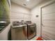 Modern laundry room equipped with stainless steel washer and dryer, and convenient overhead shelving at 171 Mark Twain Ln, Rotonda West, FL 33947