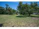 Expansive backyard with mature trees and a storage shed offering ample outdoor space at 1712 Fessler St, Englewood, FL 34223