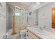 Traditional bathroom with tub and shower, floral curtain and neutral colored countertop at 1712 Fessler St, Englewood, FL 34223