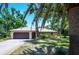 Charming single-story home with a well-manicured lawn, complemented by lush trees and landscaping at 1712 Fessler St, Englewood, FL 34223