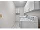 Functional laundry room features a washing machine, dryer, and storage cabinets at 1712 Fessler St, Englewood, FL 34223
