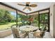 Enclosed porch with ceiling fan featuring a table and chairs set surrounded by lush greenery at 1712 Fessler St, Englewood, FL 34223