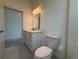 Bathroom featuring white marbled countertop, a white toilet, and stainless steel fixtures at 18043 Hillsborough Blvd, Port Charlotte, FL 33954