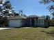 Single-Gathering home featuring a well-maintained lawn and a two-car garage at 18043 Hillsborough Blvd, Port Charlotte, FL 33954