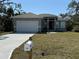 Beautifully landscaped single Gathering home with a freshly poured driveway, a two car garage, and a mailbox at 18043 Hillsborough Blvd, Port Charlotte, FL 33954