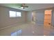 Spacious bedroom showcasing a ceiling fan, a window and an adjacent room at 19 Oakwood Dr N # 19, Englewood, FL 34223