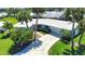 Beautiful home with tropical landscaping, a white tile roof and a paved driveway and sidewalks at 19 Oakwood Dr N # 19, Englewood, FL 34223