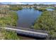 Scenic aerial view featuring a wooden bridge spanning a tranquil waterway surrounded by lush greenery at 2060 Oyster Creek Dr, Englewood, FL 34224