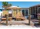 Back deck has lounge chairs, umbrella, and a view of the screened patio with a view of the waterfront at 2060 Oyster Creek Dr, Englewood, FL 34224
