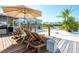 Inviting back deck with lounge chairs, umbrella, and views of the waterfront at 2060 Oyster Creek Dr, Englewood, FL 34224