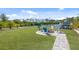 Backyard has a lawn, a fire pit with chairs, landscaping, and a view of the waterfront and boat lift at 2060 Oyster Creek Dr, Englewood, FL 34224