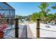 Backyard with a pathway to the waterfront, colorful chairs, and lush landscaping at 2060 Oyster Creek Dr, Englewood, FL 34224