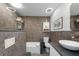 Modern bathroom with a sink, dark tile, and a unique tub and shower combo at 2060 Oyster Creek Dr, Englewood, FL 34224