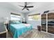 Bright bedroom featuring hardwood floors, ample lighting, and closet with shelf space at 2060 Oyster Creek Dr, Englewood, FL 34224