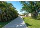 Long driveway leading to a well-maintained home with lush landscaping and ample green space at 2060 Oyster Creek Dr, Englewood, FL 34224
