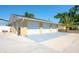 A three car garage featuring white doors and a paved driveway, perfect for parking and storage at 2060 Oyster Creek Dr, Englewood, FL 34224