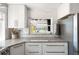 Bright kitchen featuring lake views, stainless steel appliances, granite countertops, and white cabinets at 2060 Oyster Creek Dr, Englewood, FL 34224