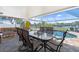 An inviting covered patio features dining and lounge seating with views of the pool and waterfront at 2060 Oyster Creek Dr, Englewood, FL 34224