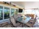 A covered patio offers dining, seating, and a flat-screen television, all with a view of the yard at 2060 Oyster Creek Dr, Englewood, FL 34224