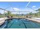 The screened-in pool area has a beautiful pool and outdoor seating with a view of the water at 2060 Oyster Creek Dr, Englewood, FL 34224
