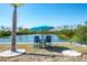 Waterfront with landscaping and chairs with umbrella, nice spot to relax on the water at 2060 Oyster Creek Dr, Englewood, FL 34224