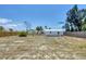 Large, fenced backyard with mature trees and a shed, offering a private outdoor space with potential for customization at 2117 Michigan Ave, Englewood, FL 34224