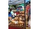 Busy farmers market stand displays fresh baked goods with masked customers and vendors at 2117 Michigan Ave, Englewood, FL 34224