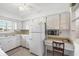 The bright, practical kitchen features white cabinetry, a dedicated desk space, and essential appliances for daily use at 2117 Michigan Ave, Englewood, FL 34224