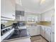 Functional kitchen featuring white cabinetry, essential appliances, and a window over the sink for natural light at 2117 Michigan Ave, Englewood, FL 34224