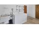 Bright laundry room with white washer and dryer, utility sink, and shelving; perfect for efficient home chores at 2117 Michigan Ave, Englewood, FL 34224