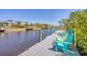 Dock on the water with colorful Adirondack chairs offers space to relax at 2441 Vance Ter, Port Charlotte, FL 33981