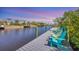 Relax on the waterfront dock with colorful Adirondack chairs and tranquil water views at 2441 Vance Ter, Port Charlotte, FL 33981