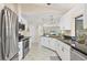 Bright kitchen features white cabinets, stainless steel appliances, and granite countertops, with an open view to the living area at 2441 Vance Ter, Port Charlotte, FL 33981