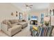 Comfortable living room with large sectional sofa, ceiling fan, and a flat screen TV with a view of the beach at 2441 Vance Ter, Port Charlotte, FL 33981